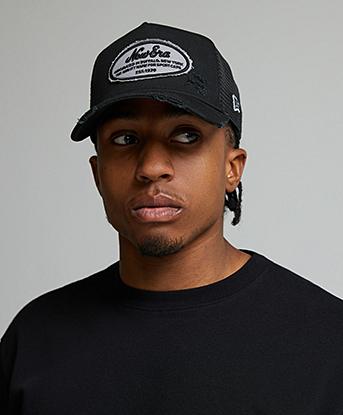 New Era Oval Distressed Trucker Patch Cap in Black